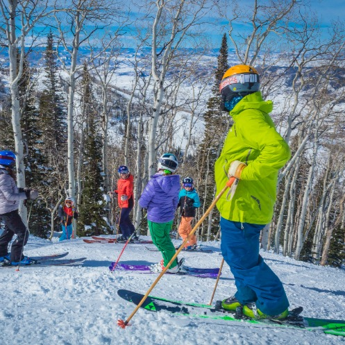 group of people enjoying a ski lesson together on a sunny day