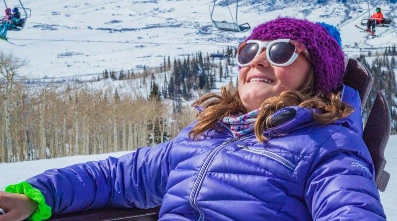 Kid sitting in chair with sunglasses on mountain