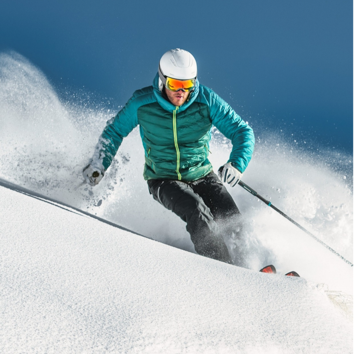 skiers on groomed slopes and among trees